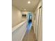 Hallway with wood-look floors, white walls, art, and doorways leading to other rooms at 9208 Hillcroft Dr, Riverview, FL 33578