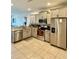 Well-lit kitchen featuring stainless steel appliances, granite counters, tile flooring, and light grey cabinets at 9208 Hillcroft Dr, Riverview, FL 33578