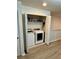 Laundry closet containing a new front load washer and dryer with shelving for supplies at 9208 Hillcroft Dr, Riverview, FL 33578
