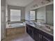 Bathroom with double sinks, granite countertops, and large soaking tub at 9244 Bella Vita Cir, Land O Lakes, FL 34637