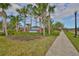 Landscaped entrance to the community featuring mature palm trees and a welcoming sign at 9244 Bella Vita Cir, Land O Lakes, FL 34637
