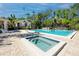 Community pool and spa featuring a blue pool, hot tub and white pool house on a sunny day at 944 San Carlos Ne Ct, St Petersburg, FL 33702