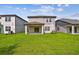 Backyard view of home with covered patio, sliding door and well-maintained lawn at 10352 Cross River Trl, Parrish, FL 34219