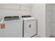 Well-equipped laundry room featuring modern washer and dryer units and wire shelving at 10352 Cross River Trl, Parrish, FL 34219