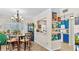 Charming dining area featuring a modern chandelier, stylish bar stools, and vibrant artwork connecting to the kitchen at 10736 Keys Gate Dr, Riverview, FL 33579