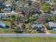 An aerial view captures a home with screened pool, nestled amongst mature trees in a serene neighborhood setting at 10925 Fort King Rd, Dade City, FL 33525