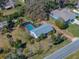 Aerial view of a charming home featuring a screened-in pool and lush landscaping in a tranquil neighborhood at 10925 Fort King Rd, Dade City, FL 33525