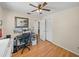 Bedroom with hardwood floors, a ceiling fan, and a desk with computer monitors at 10925 Fort King Rd, Dade City, FL 33525
