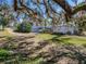 Exterior view of the home with a two-car garage, screened-in pool, and a well-manicured lawn at 10925 Fort King Rd, Dade City, FL 33525