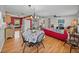 Spacious open-concept living and dining area with hardwood floors, a red accent wall, and ample natural light at 10925 Fort King Rd, Dade City, FL 33525