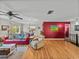 Spacious living room with hardwood floors, a red accent wall, comfortable seating, and views of the dining area at 10925 Fort King Rd, Dade City, FL 33525