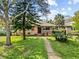 A charming home with a well-manicured lawn, lush landscaping, and a welcoming walkway leading to the front door at 1520 15Th N St, St Petersburg, FL 33704