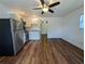 Open-concept living space and kitchen featuring wood floors and ceiling fan with stainless steel refrigerator at 1520 15Th N St, St Petersburg, FL 33704