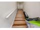 A clean and well-lit staircase with wooden steps, white risers, and a handrail leading upwards at 1520 15Th N St, St Petersburg, FL 33704