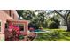 A lush backyard boasts green grass, fresh mulch, and a large swimming pool at 1550 Chateau Wood Dr, Clearwater, FL 33764