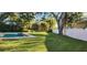 Expansive backyard featuring a well-maintained lawn, pool, and lush trees at 1550 Chateau Wood Dr, Clearwater, FL 33764