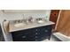 Bathroom with a double vanity featuring granite countertops, modern faucets, and dark wood cabinets at 1550 Chateau Wood Dr, Clearwater, FL 33764