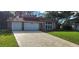 Charming two-story home with a well-manicured lawn and a spacious three-car garage at 1550 Chateau Wood Dr, Clearwater, FL 33764