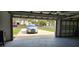 View from inside the epoxy garage looking out onto the paved driveway at 1550 Chateau Wood Dr, Clearwater, FL 33764
