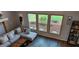 Bright living room featuring large windows, a comfortable couch, and stylish decor at 1550 Chateau Wood Dr, Clearwater, FL 33764