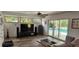 Bright living room with a large sliding glass door to the pool and modern entertainment center at 1550 Chateau Wood Dr, Clearwater, FL 33764