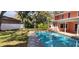Inviting pool with brick surround in a spacious yard at 1550 Chateau Wood Dr, Clearwater, FL 33764