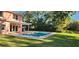Backyard showcasing a pristine swimming pool and an inviting outdoor space surrounded by lush greenery at 1550 Chateau Wood Dr, Clearwater, FL 33764
