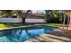 Sparkling pool in a backyard oasis, with a view of the expansive green lawn and shaded areas at 1550 Chateau Wood Dr, Clearwater, FL 33764