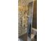 Walk-in shower featuring unique brown and gold tile design, plus a modern shower head and glass door at 1550 Chateau Wood Dr, Clearwater, FL 33764