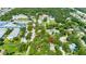 Aerial view of a home in a community with a variety of buildings, schools, and surrounding neighborhoods at 1857 Castle Woods Dr, Clearwater, FL 33759