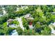 Aerial view of a home nestled among lush green trees in a quiet neighborhood at 1857 Castle Woods Dr, Clearwater, FL 33759
