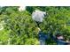 Aerial view of a home with lush tree cover and a detached garage, showcasing its peaceful neighborhood setting at 1857 Castle Woods Dr, Clearwater, FL 33759