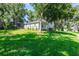 Backyard view of the home showcasing the mature trees and a screened in porch at 1857 Castle Woods Dr, Clearwater, FL 33759