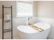 Elegant bathroom features a freestanding tub with a modern faucet and a towel ladder at 1857 Castle Woods Dr, Clearwater, FL 33759