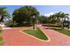 Streetscape view with clock, manicured landscaping, and brick-paved walkway at 1857 Castle Woods Dr, Clearwater, FL 33759