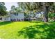 Charming two-story home with lush front yard and mature trees with colorful garden at 1857 Castle Woods Dr, Clearwater, FL 33759