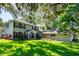 Charming two-story home with lush front yard and manicured garden with mature trees at 1857 Castle Woods Dr, Clearwater, FL 33759