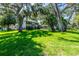 Charming two-story home with lush front yard and mature trees with Spanish moss at 1857 Castle Woods Dr, Clearwater, FL 33759
