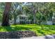 Charming two-story home with lush front yard and mature trees with Spanish moss at 1857 Castle Woods Dr, Clearwater, FL 33759