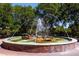 Outdoor fountain in manicured garden setting with park benches and shade trees at 1857 Castle Woods Dr, Clearwater, FL 33759