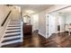 Entryway featuring hardwood floors, staircase, dresser, and ample natural light at 1857 Castle Woods Dr, Clearwater, FL 33759