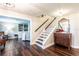 Open foyer featuring hardwood floors, a staircase, a dresser, and an entry to the living room at 1857 Castle Woods Dr, Clearwater, FL 33759