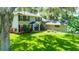 Exterior of a traditional home featuring a lush lawn, mature trees and welcoming curb appeal at 1857 Castle Woods Dr, Clearwater, FL 33759