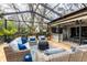 Spacious screened-in patio with comfortable seating, wood decking, and an outdoor bar area at 1857 Castle Woods Dr, Clearwater, FL 33759