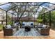 Inviting screened-in patio boasts ample seating, a cozy fire pit, and a relaxing atmosphere at 1857 Castle Woods Dr, Clearwater, FL 33759