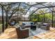 Inviting screened-in patio boasts ample seating, a cozy fire pit, and a relaxing atmosphere at 1857 Castle Woods Dr, Clearwater, FL 33759