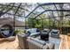 Inviting screened-in patio boasts ample seating, a cozy fire pit, and a relaxing atmosphere at 1857 Castle Woods Dr, Clearwater, FL 33759