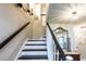 Elegant staircase with dark wood railings and white risers leads to the upper level at 1857 Castle Woods Dr, Clearwater, FL 33759