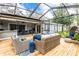 Enclosed patio shows wood flooring, open roof, and wicker furniture perfect for outdoor living and entertaining at 1857 Castle Woods Dr, Clearwater, FL 33759