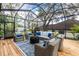 Screened lanai boasts vaulted ceiling, wood flooring, and comfortable wicker furniture for relaxing and enjoying the outdoors at 1857 Castle Woods Dr, Clearwater, FL 33759